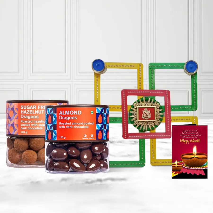 Hazelnut and almond dragees in colorful packaging with a decorative candle diya and rangoli design, accompanied by a Diwali greeting card.