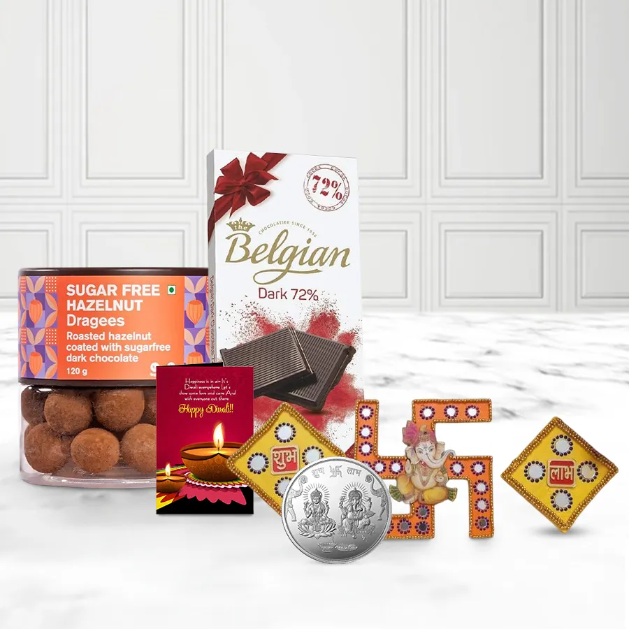 Blissful Belgian Bar N Sugar-Free Hazelnut Dragee gift basket featuring Belgian chocolate, hazelnut dragees, a silver-plated Ganesh Laxmi coin, Shubh Labh N Swastik gate decor pieces, and a Diwali card.