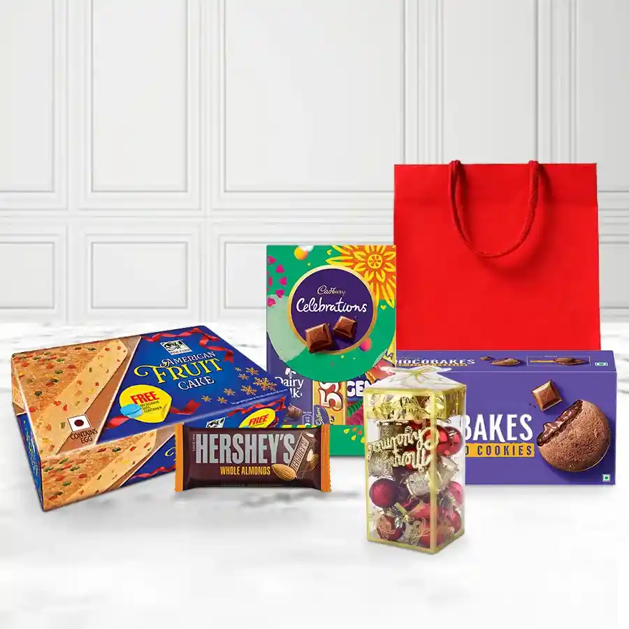 A festive hamper filled with delicious Christmas chocolate treats, including an American Fruit Cake, Hershey’s Almond Chocolate Bar, Cadbury Celebrations Mini, and Cadbury Chocobakes, all beautifully decorated with charming Christmas ornaments in a gift bag.
