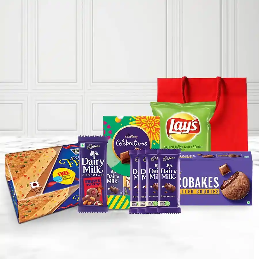 Magical Chocolicious Gift Hamper for Christmas featuring an American Fruit Cake, Cadbury Fruit & Nut, assorted Dairy Milk bars, Chocobakes, Celebration Minis, and crispy potato chips in an elegant gift bag.