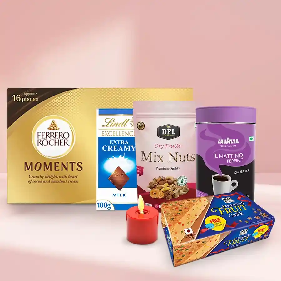 Delicious Xmas Treat Assortments Gift Hamper featuring American Fruit Cake, Lindt Excellence Bar, Ferrero Rocher Moments, mixed nuts, Lavazza Coffee, and a pillar candle in a festive presentation.
