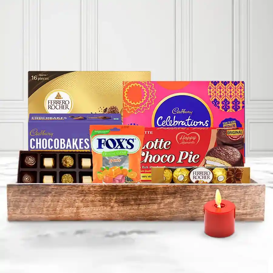 Delectable tray filled with assorted Christmas chocolates and a cozy pillar candle on a wooden tray