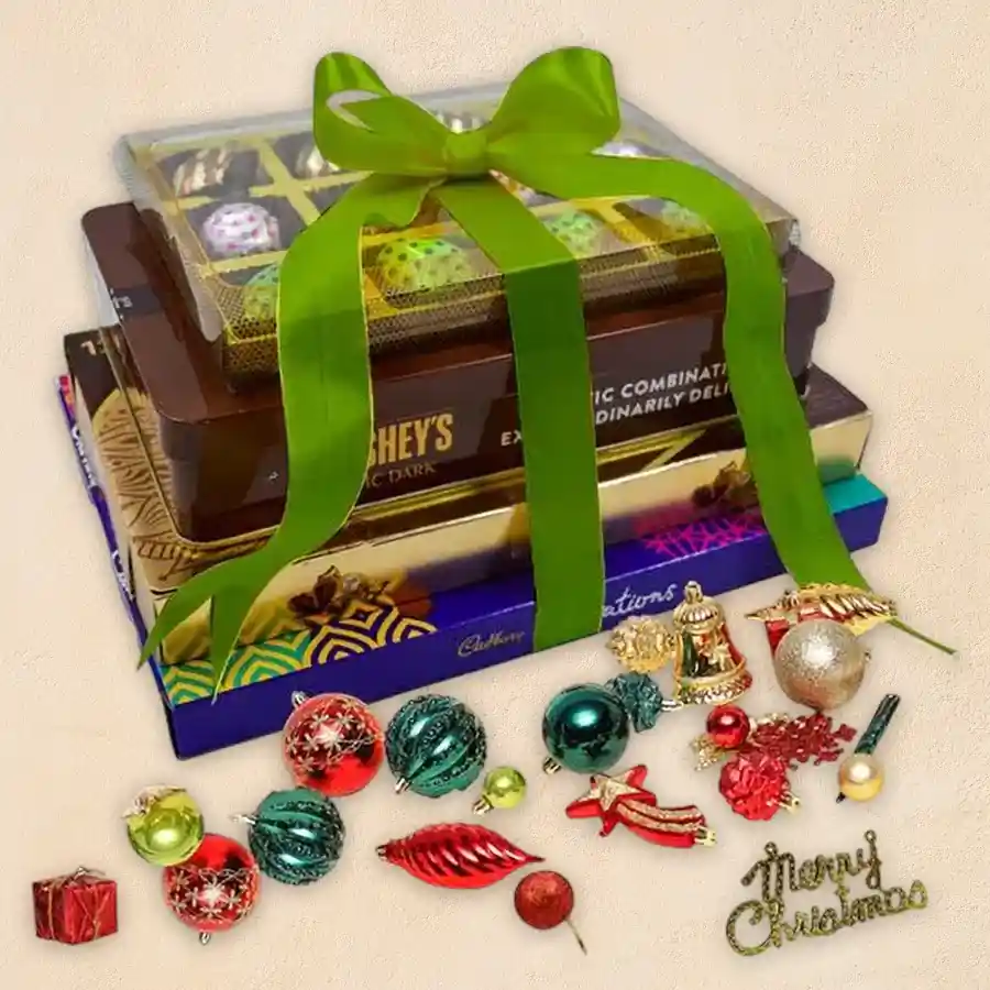 Premium 4-layered chocolate tower adorned with festive Christmas decorations featuring Ferrero Rocher Moments, Hershey’s Kisses, Cadbury Celebrations, and handmade chocolates.