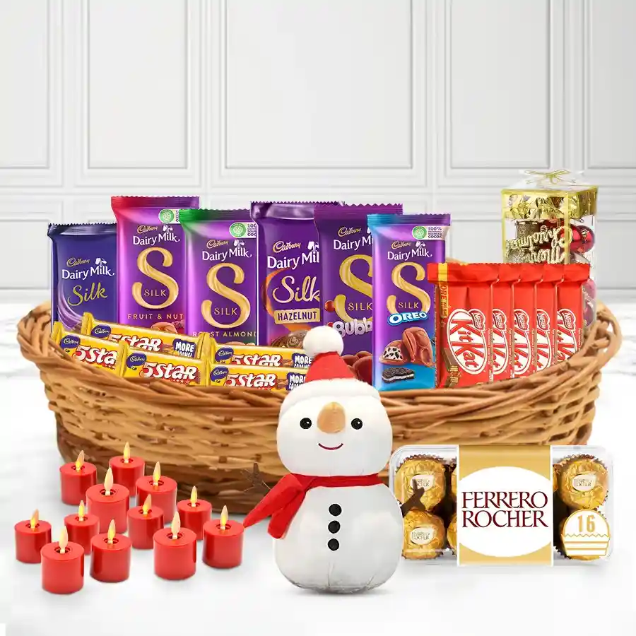 Gift basket filled with assorted chocolates, including Cadbury, Nestle, and Ferrero Rocher, decorated with Christmas ornaments, a snowman, and glowing candles.