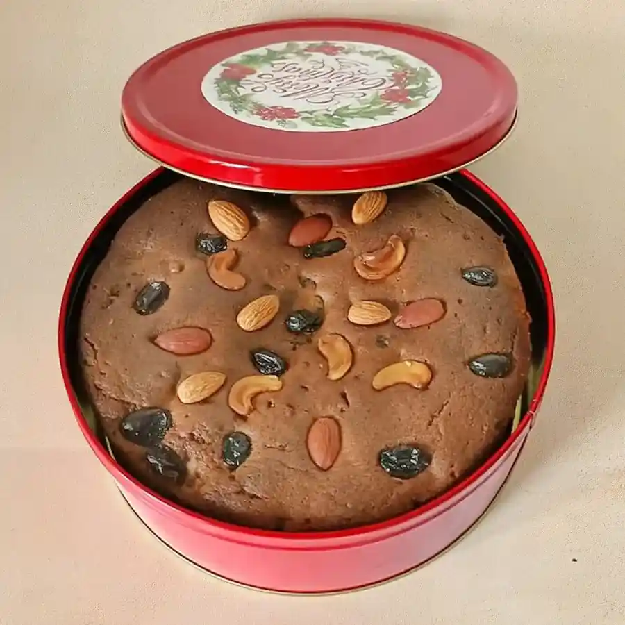 A delicious Confectionery Rich Plum Cake garnished with plums, displayed on a decorative plate.