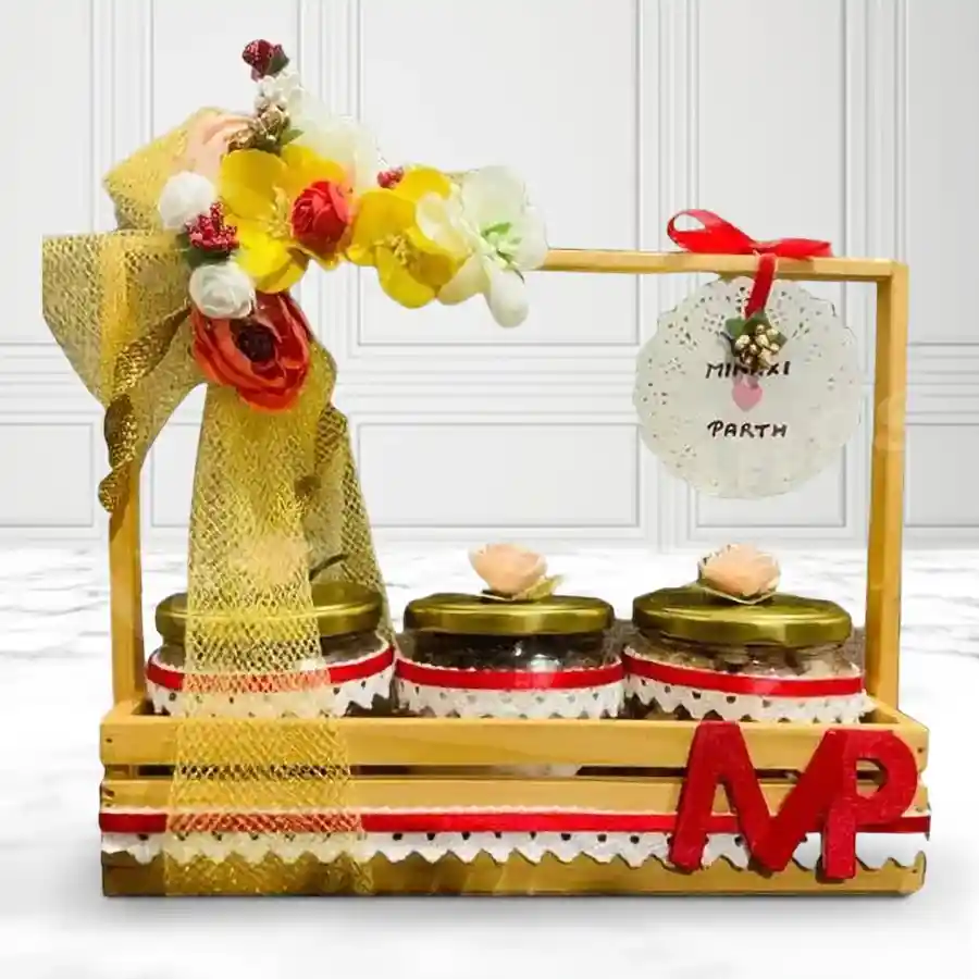 Elegant glass jar filled with assorted dry fruits, presented in a designer wooden holder tray for a wedding anniversary gift.