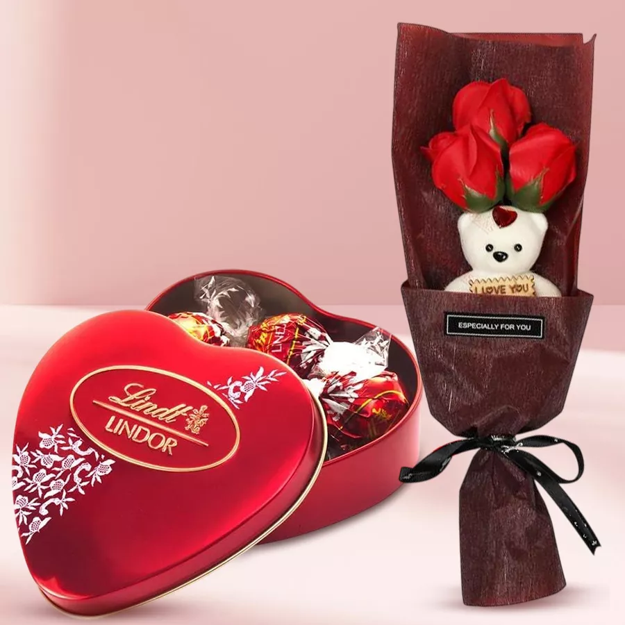 Bouquet of artificial red roses with a teddy bear and a box of Lindt Lindor chocolates