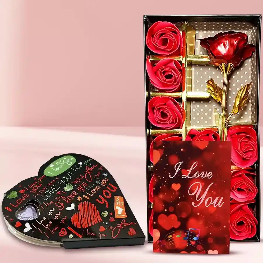 Artificial red roses with heart-shaped chocolates and a heartfelt card in a red box