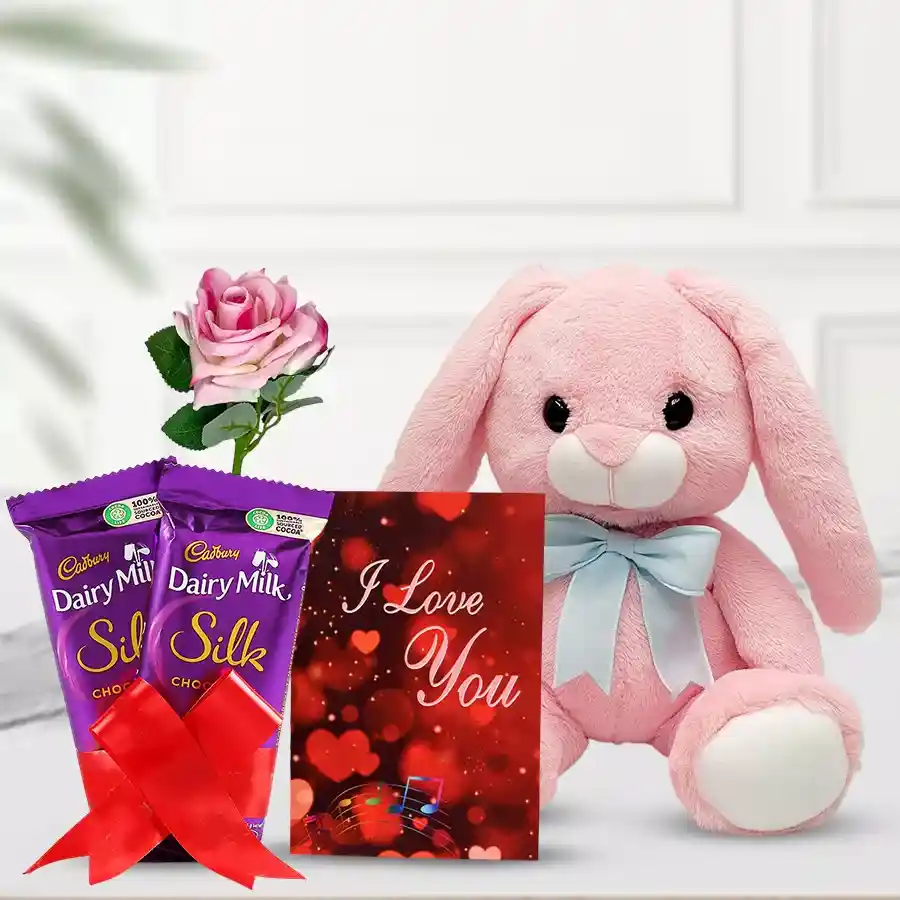 Adorable pink soft bunny with Cadbury Silk chocolates, a pink rose, and an "I Love You" card, creatively arranged for Valentine's Day.