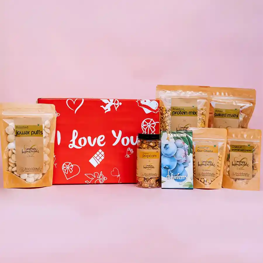 Delicious Gourmet Gift Hamper for Valentine's Day filled with treats like Baked Mathi, Caramel Popcorn, Chocolate Slab, Roasted Protein Mix, Gourmet Aampapad, Gur Chana, and Jowar Puffs
