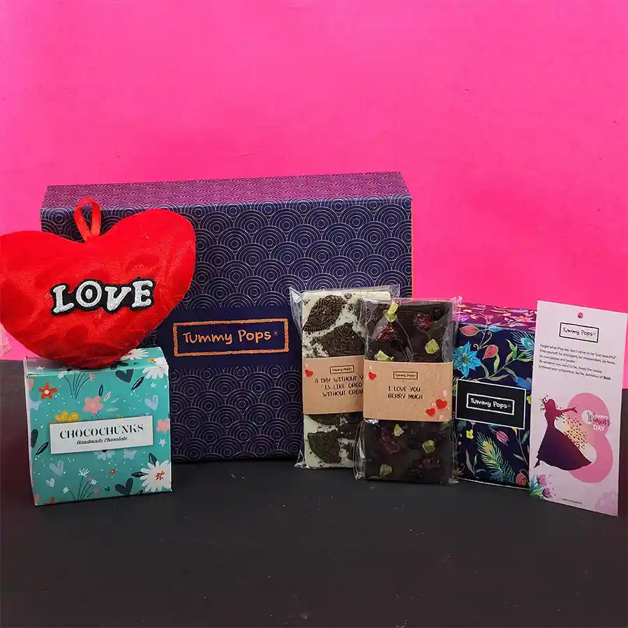 Assorted gift box featuring chocolates, mukhwas, a heart-shaped pillow, and a diary bookmark