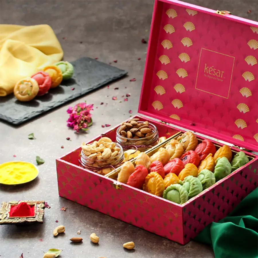 Premium Roasted Dry Fruits with Assorted Chandrakala Herbal Colors in a stylish pink box, featuring crunchy cashews, almonds, vibrant herbal colors, and a Holi greeting card.