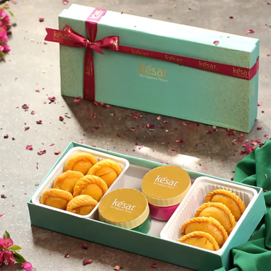 Holi gift pack featuring Kesar Gujiya, Chandrakala, two jars of eco-friendly gulal, and a Holi greeting card in a festive box.