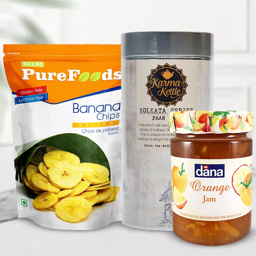 Crunchy Banana Chips with Karma Kettle Paan Cha and Dana Jam gift bundle displayed on a wooden surface