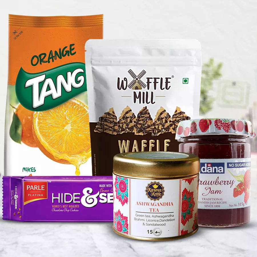 Amazing Hamper of Ashwagandha Tea with Tang Juice, Parle Hide & Seek biscuits, Dana Jam, and Waffle Mills arranged beautifully