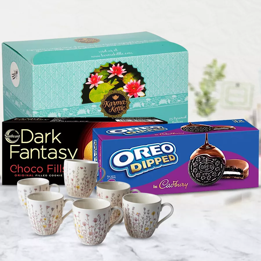 Relaxing Karma Kettle Moksha Tea with Cookies N Cup Set featuring tea bags, a chic cup set, ITC Dark Fantasy chocolates, and Cadbury Oreo Dipped Biscuits.