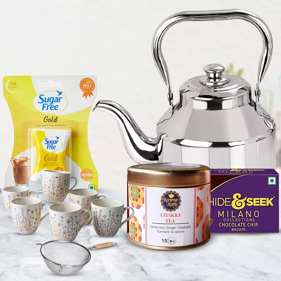 Refreshing Chakra Tea Gift Hamper with tea bags, a cup set, a stainless steel kettle, sugar-free packets, and Milano cookies