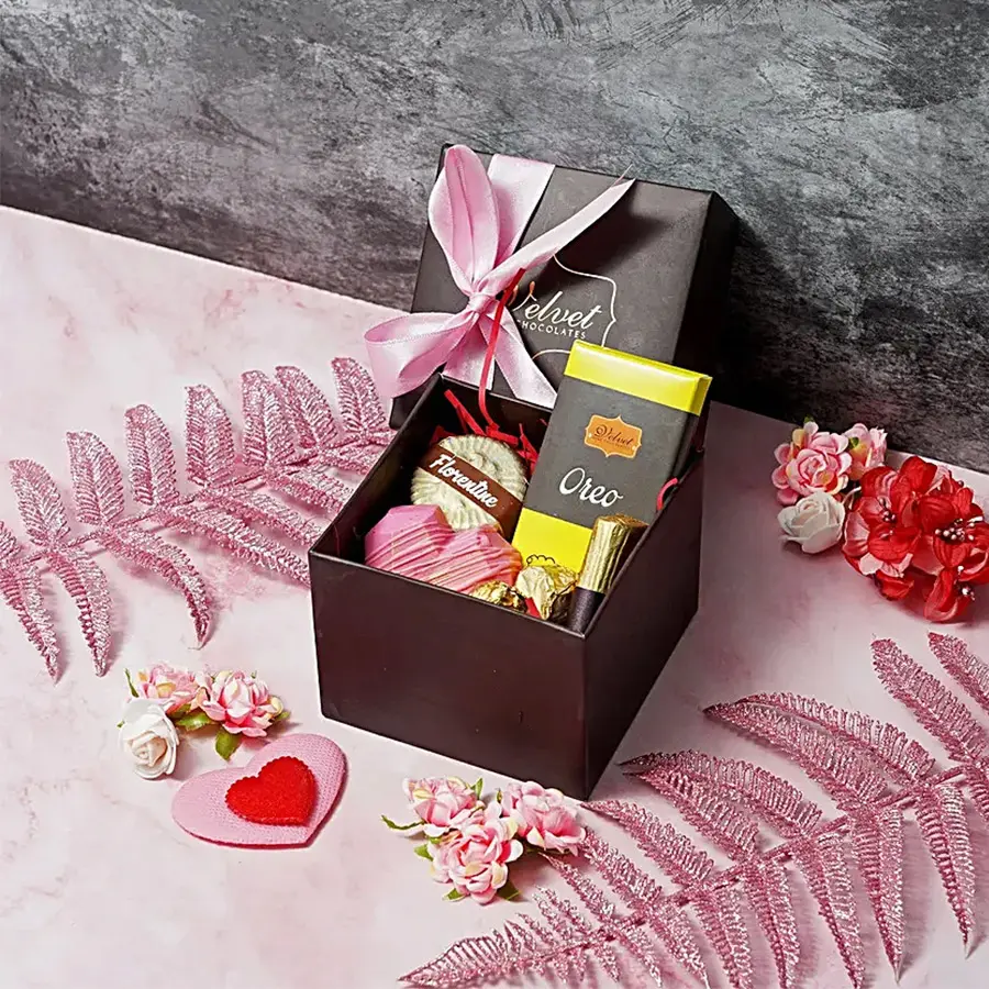 Indulgent chocolates gift box for Mother's Day featuring an Oreo chocolate bar, almond florentines, chocolate almond rocks, a chocolate log, and a mini heart-shaped piñata.