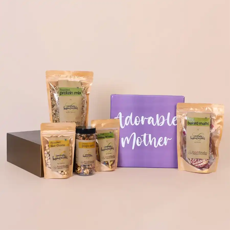 Enchanting Snacks Gift Hamper for Mom with assorted treats including roasted protein mix, crispy baked Mathi, crunchy Gur Chana, sweet caramel popcorn, and moong dal twisties.