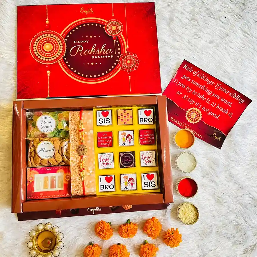 Tempting Choco Nuts N Rakhi Combo Gift featuring a Designer Metal Mauli Rakhi, handcrafted chocolates, almonds, dried mixed fruits, traditional treats, and a Rakhi Greeting Card.