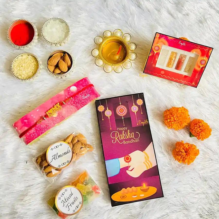 Trendy Rakhi and gifts for brother hamper featuring a vibrant designer rakhi, chocolate bar, premium almonds, mixed fruits, and a complimentary rakhi greeting card.