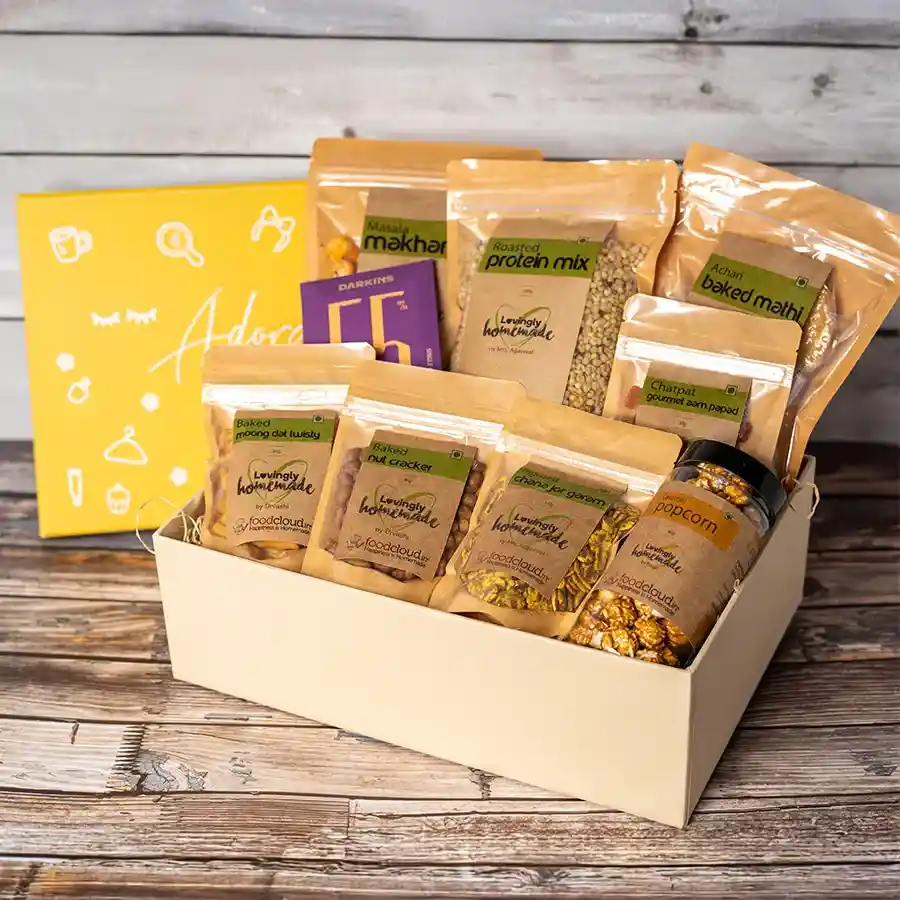 Rakshabandhan Special Pack of 9 Munchies Magic for Sis featuring an assortment of snacks including crispy baked mathi, roasted makhana, sweet caramel popcorn, and rich chocolate slabs.