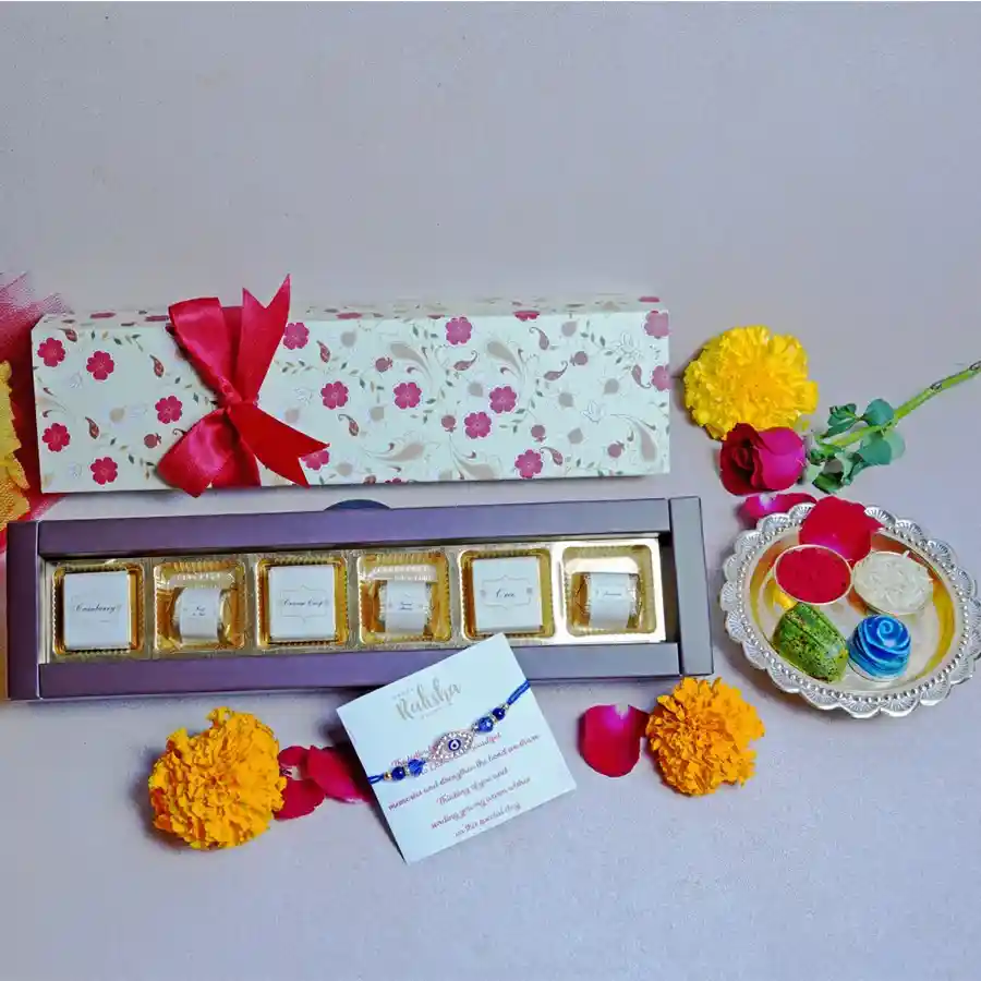 Premium Chocolate Rakhi Hamper featuring a designer rakhi, assorted chocolates, and a Rakhi greetings card on a decorative background.