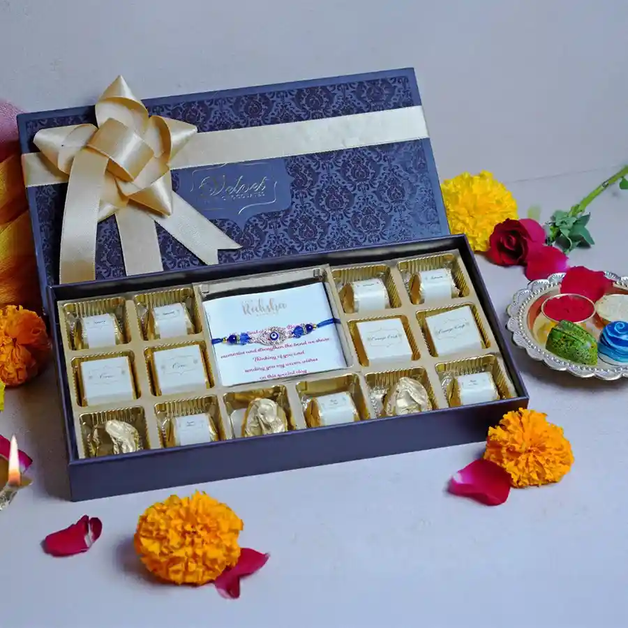 Sweetness Unlimited Box featuring 10 chocolates in five flavors, 3 chocolate almond rocks, a designer rakhi, and a greeting card, all elegantly presented in a decorative box.