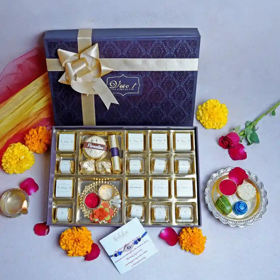 Sweet Bonding Box featuring assorted chocolates, almond florentines, almond rocks, orange crisp log, kumkum thali, designer rakhi, and greeting card in an elegant gift box.