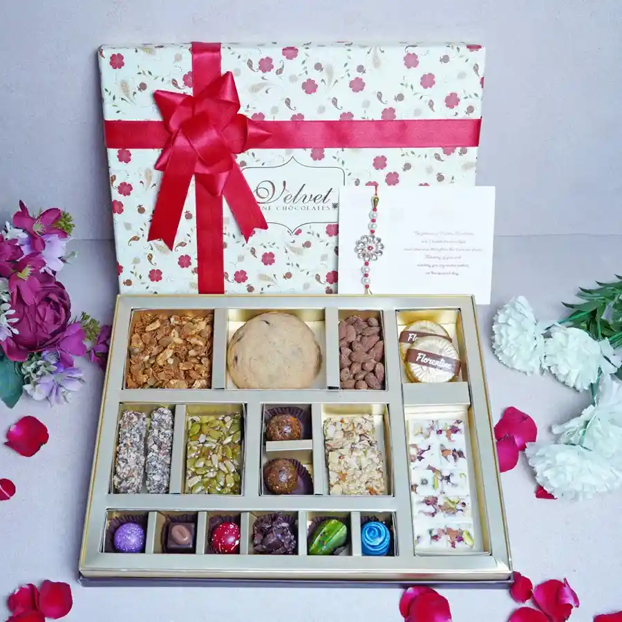Raksha Bandhan Special Chocolate Box containing assorted chocolates, nuts, cookies, and a Rakhi in a floral packaging.