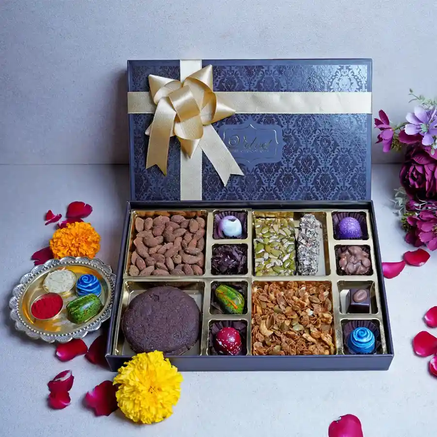 Sweet Craving Box featuring crunchy masala nuts, fudgy cookies, wholesome granola, seed squares, almond fingers, assorted chocolates, a stylish Rakhi, and a heartfelt greeting card, all beautifully packaged in a decorative box.