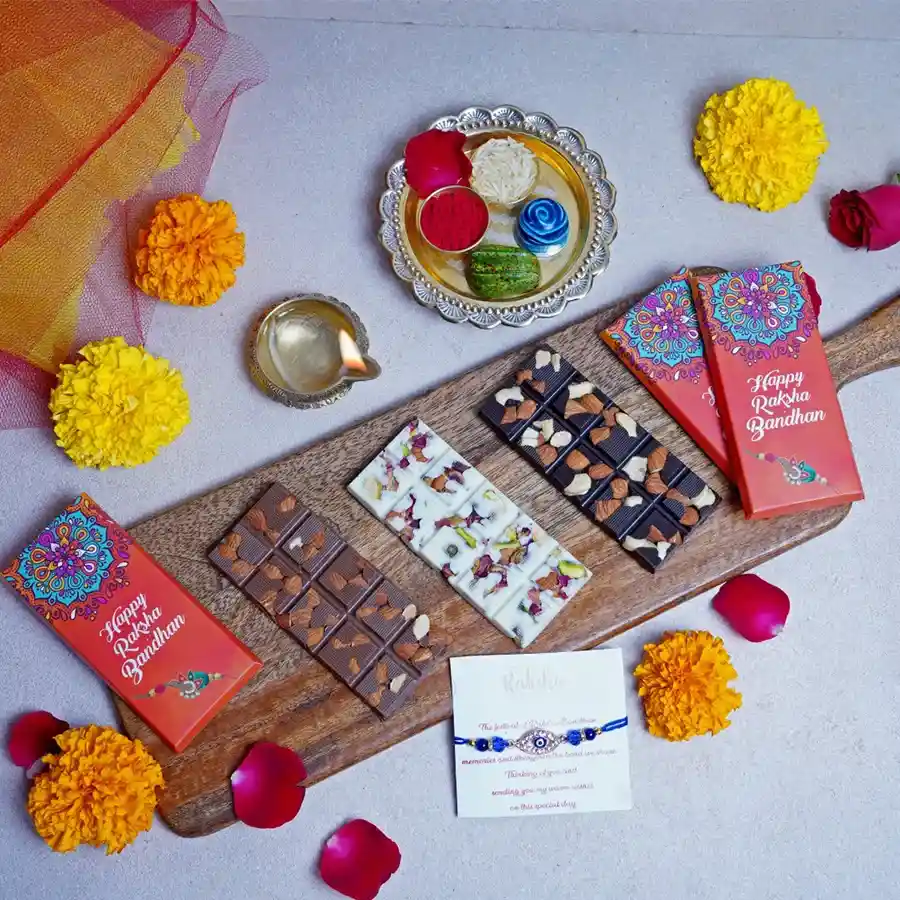 Elegant box containing Rakhi Chocolate Bar Delight with three chocolate bars (Roasted Almond, Fruit n’ Nut, and Pistachio), a stylish designer rakhi, and a heartfelt greeting card.