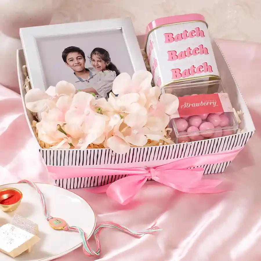 Blooming Gift Hamper including Strawberry Dragees, Strawberry Cookies, personalized frame, flower arrangement, Kappy Tray, and Meenakari Rakhi