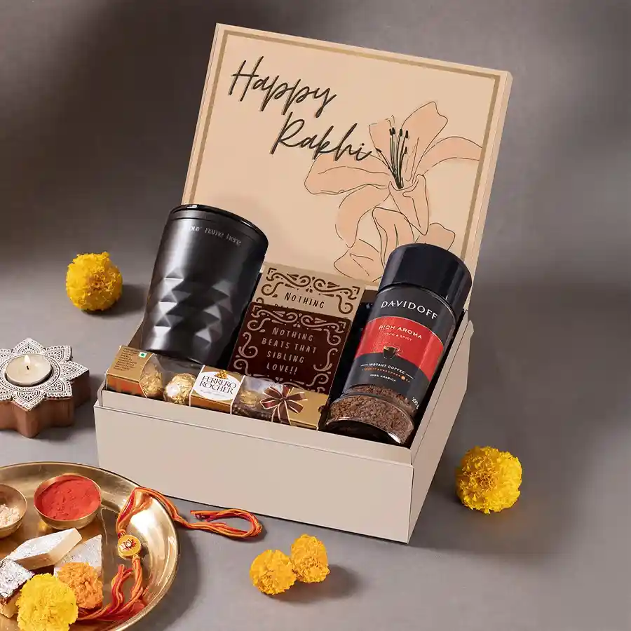 Comfee Rakhi Hamper featuring Davidoff Coffee, personalized black tumbler, stylish MDF coasters, Ferraro chocolates, reusable Happy Rakhi box, and vibrant Meenakari Rakhi.