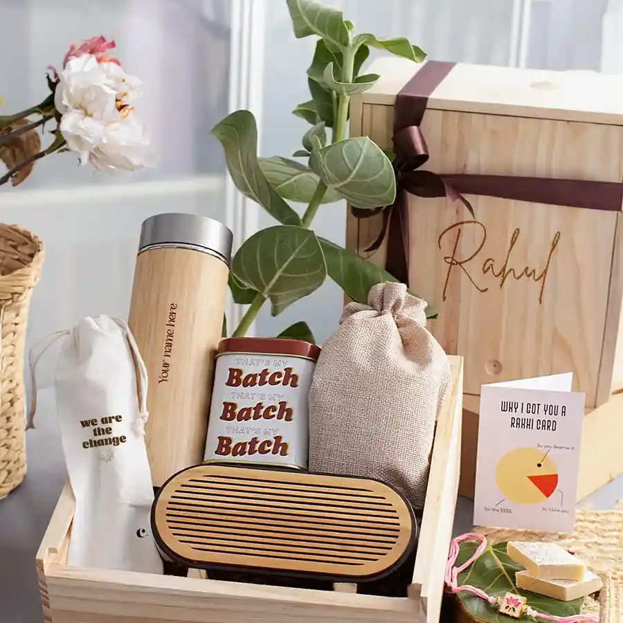 Personalized Gift Hamper for Brother featuring a bamboo flask, chocolate cookies, wooden mobile sound amplifier, mixed dry fruits, stylish utensils, meenakari rakhi, and a reusable pinewood box.