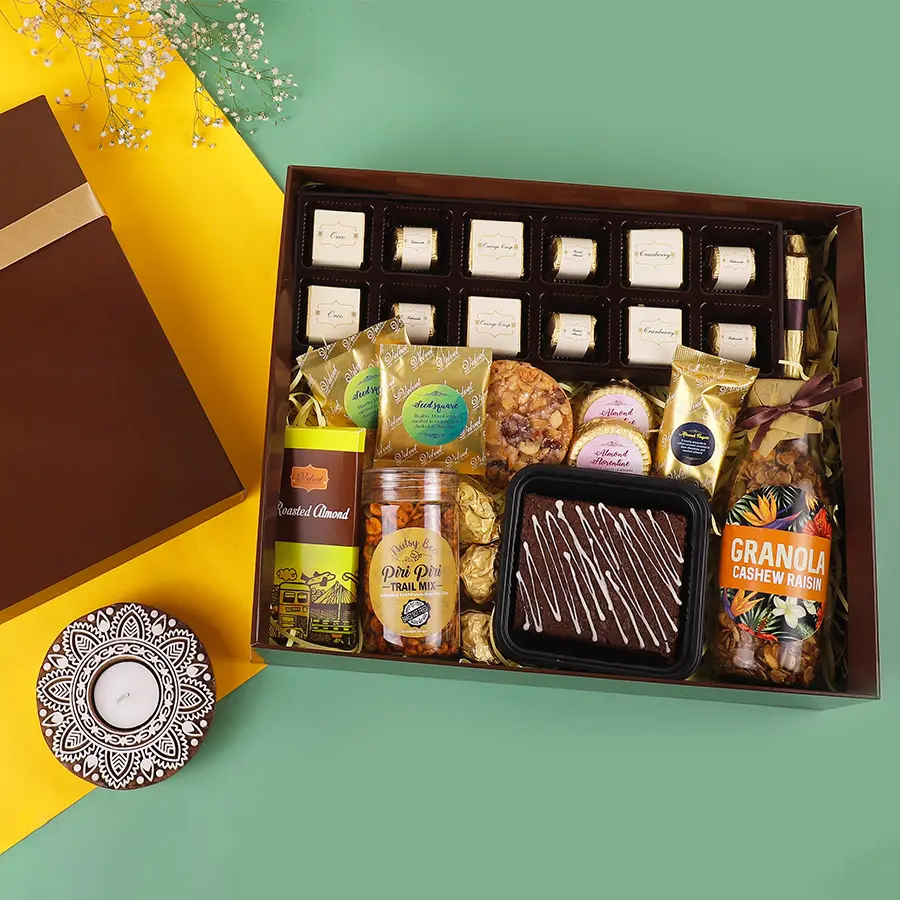 A beautifully arranged box filled with a variety of handcrafted chocolates, seed squares, brownies, florentines, granola, trail mix, and chocolate bars, designed for Diwali celebrations.