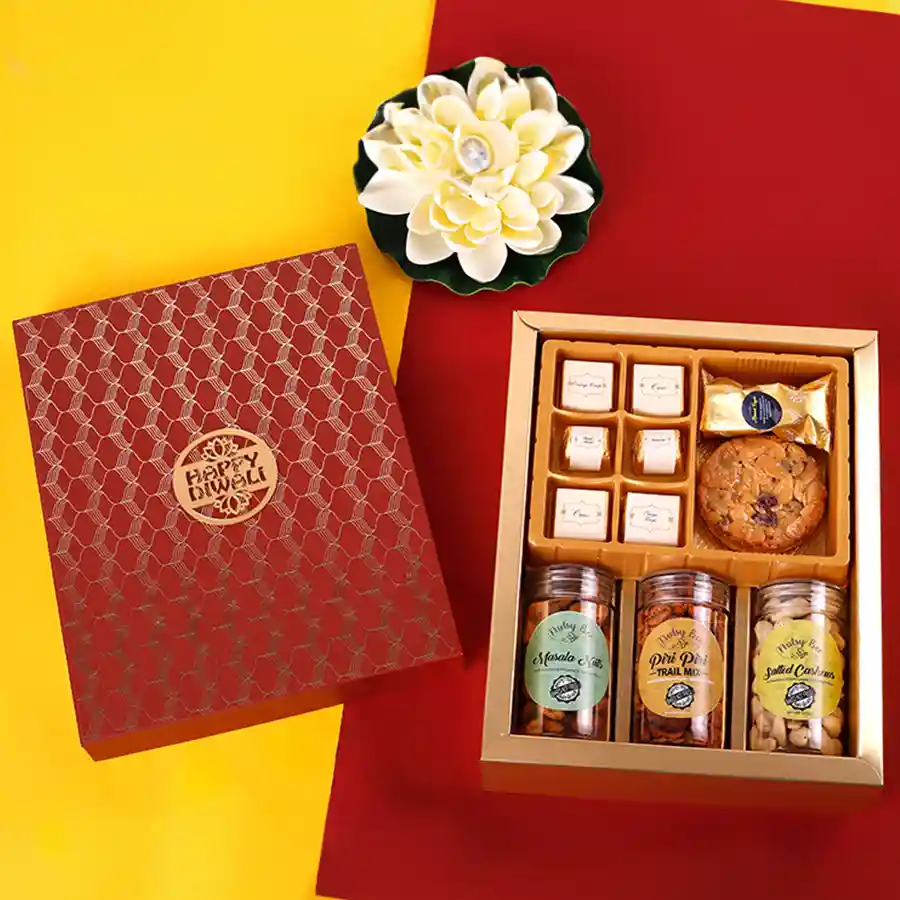 Deluxe Nut N Chocolate hamper with various chocolates, roasted almonds, almond chocolate fingers, florentine cookies, piri piri trail mix, salted cashews, and masala nuts for Diwali celebration.