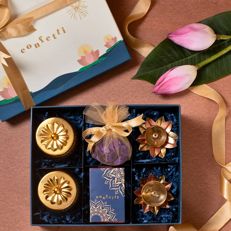 Diwali Game N Gift Set featuring playing cards, purple potpourri in a potli, brass diyas, golden handi jars with dry fruits and seed mixes, and a Diwali lantern.
