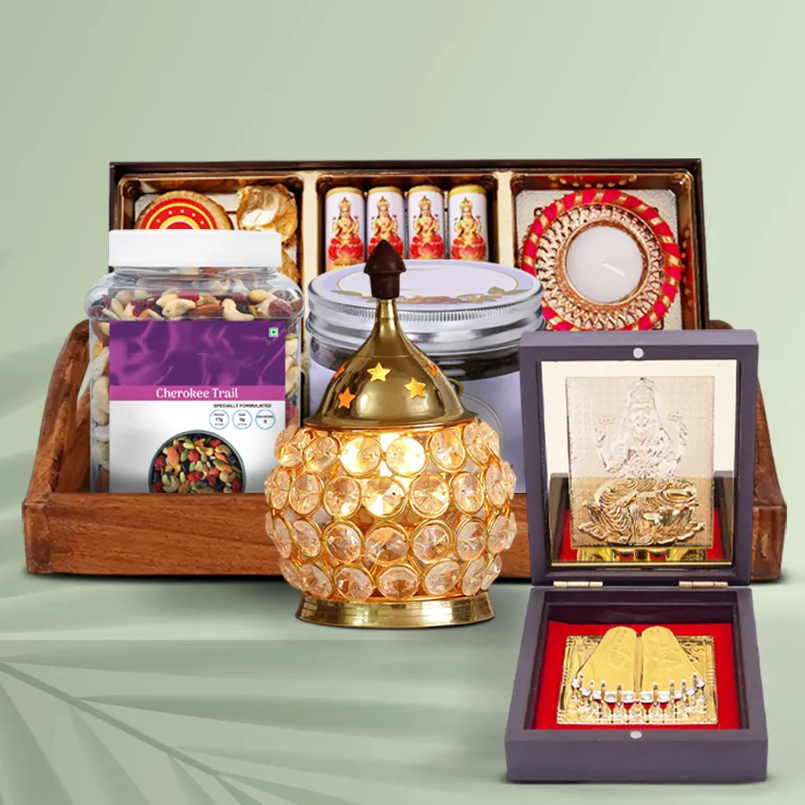 Festive Diwali Gourmet Collection displayed in an elegant wooden tray featuring a Ganesh Lakshmi prayer box, exotic trail mix, kismis kala khatta, Ferrero Rocher, cracker-shaped chocolates, and a brass crystal diya.