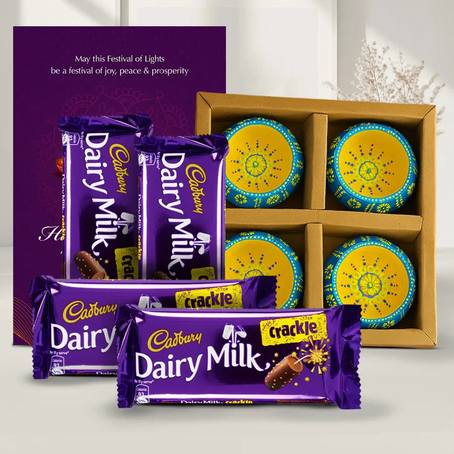 Festive Treats N Gifts Box featuring Cadbury Dairy Milk Crackle chocolates, handmade clay diyas, and a Happy Diwali card, beautifully arranged for the Diwali celebration.