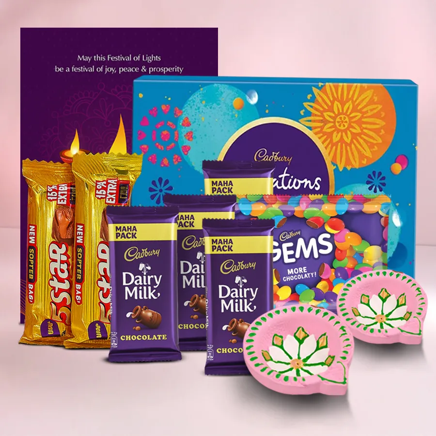 A decorative box filled with assorted Cadbury chocolates, accompanied by two handcrafted clay diyas and a Happy Diwali card, set against a festive background.