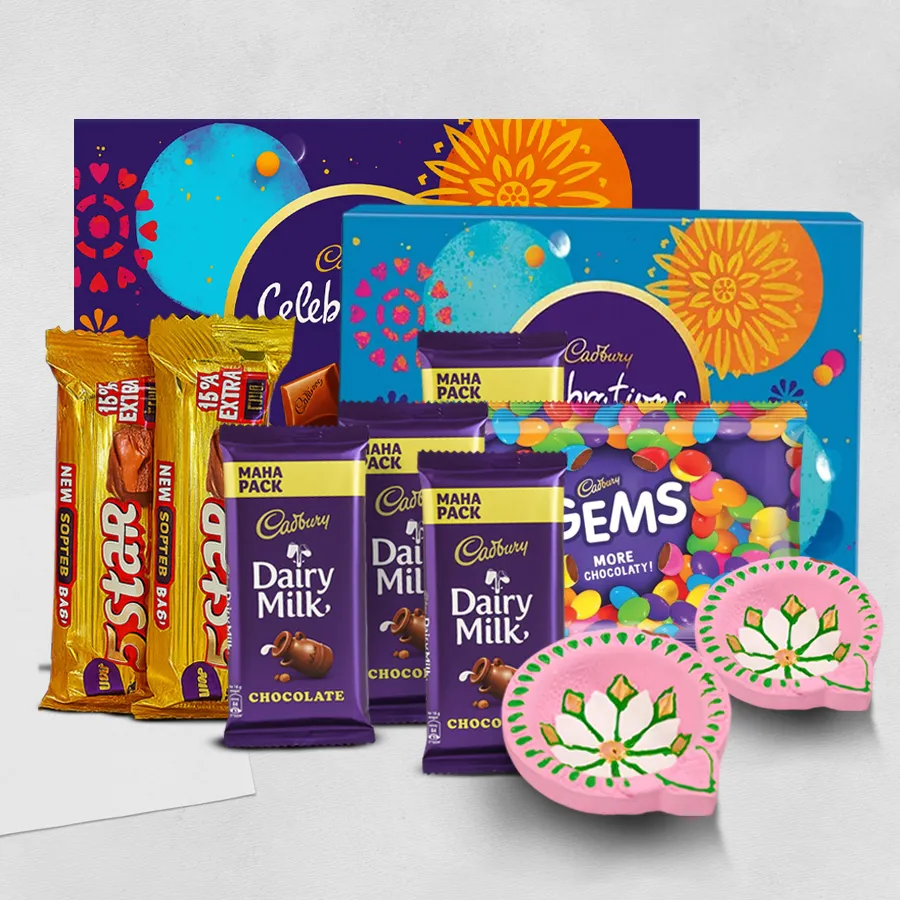 Gift box featuring an assortment of Cadbury chocolates, including Celebrations, Dairy Milk, 5 Star, and Gems, alongside two handmade clay diyas, all set against a festive background for Diwali.