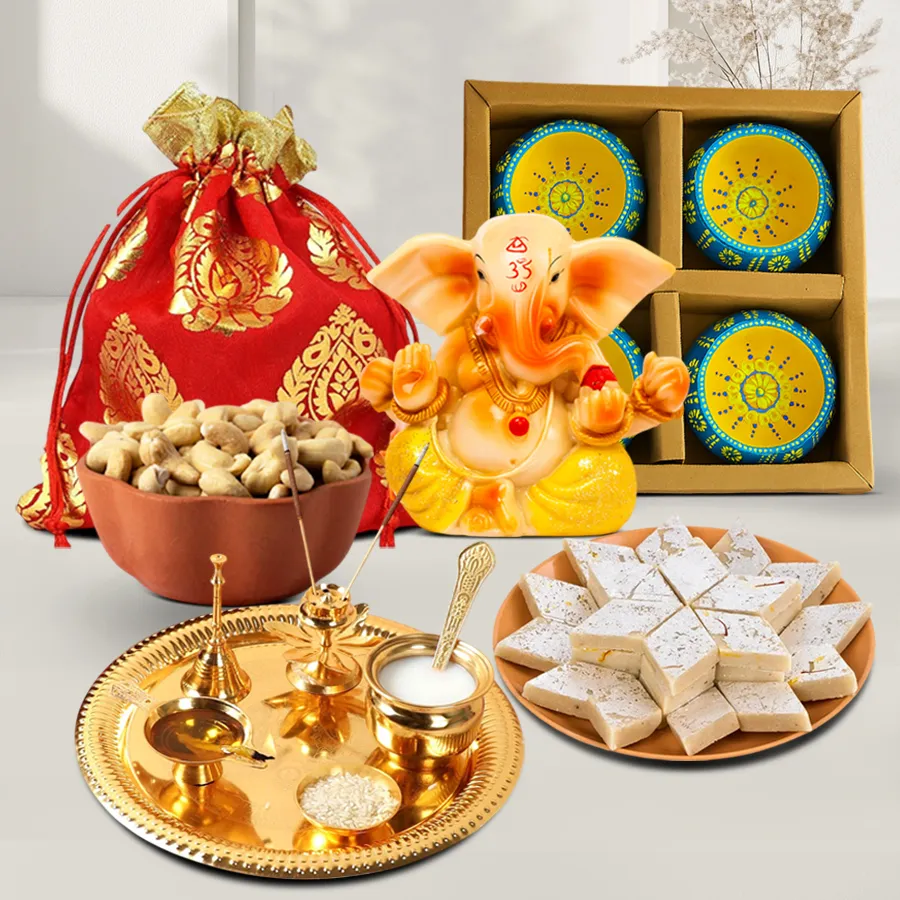 Dazzling Diwali Blessings Hamper featuring Vignesh Ganesh idol, Kaju Katli, designer potli of cashews, golden-plated Pooja thali, and clay diyas displayed together