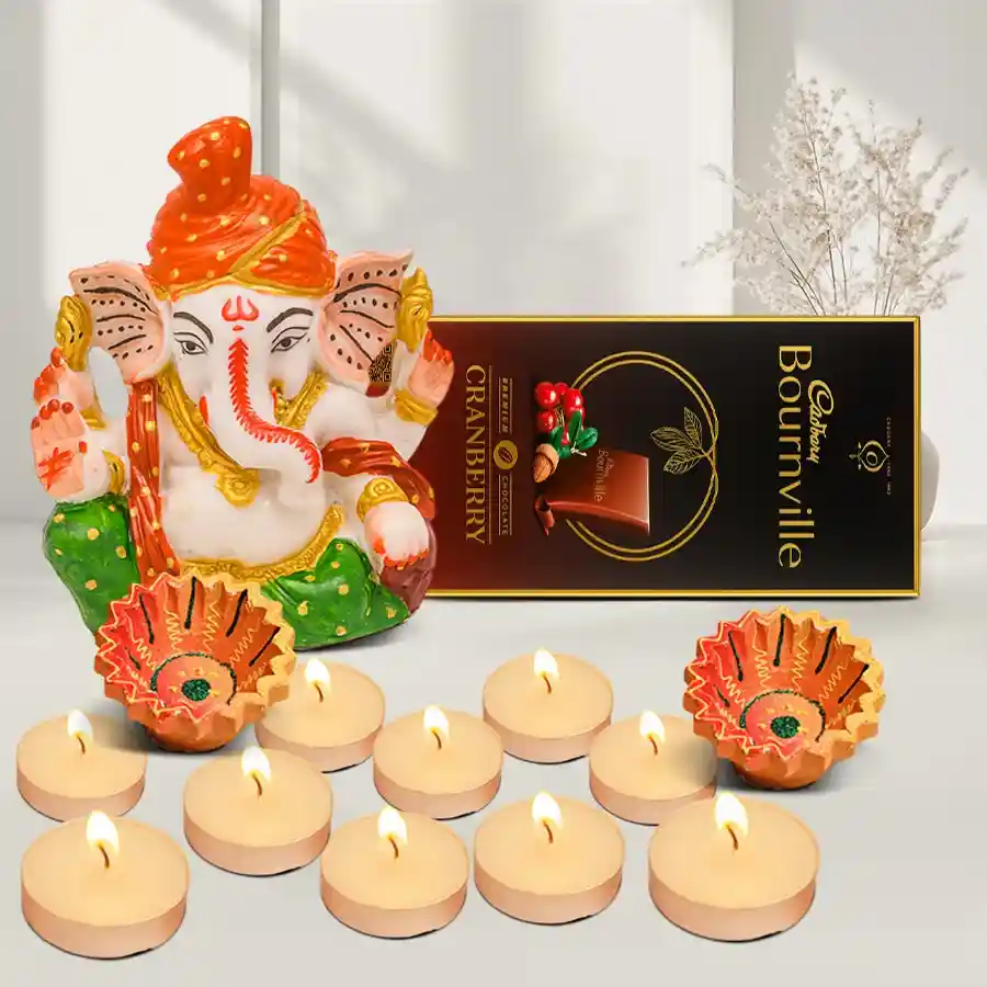 Enchanted Diwali Glow Set featuring a Pagdi Ganesh idol, scented T-light candles, designer clay diyas, and Cadbury Bournville Cranberry chocolate arranged in a festive hamper.