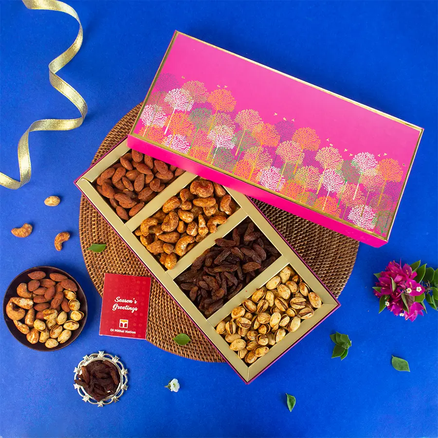 A Classic Pink Tree Box filled with an assortment of gourmet nuts including Peri Peri Cashews, Barbeque Almonds, Masala Garlic Pistachios, and Shahi Paan Raisins, accompanied by a Festive Greeting Card.