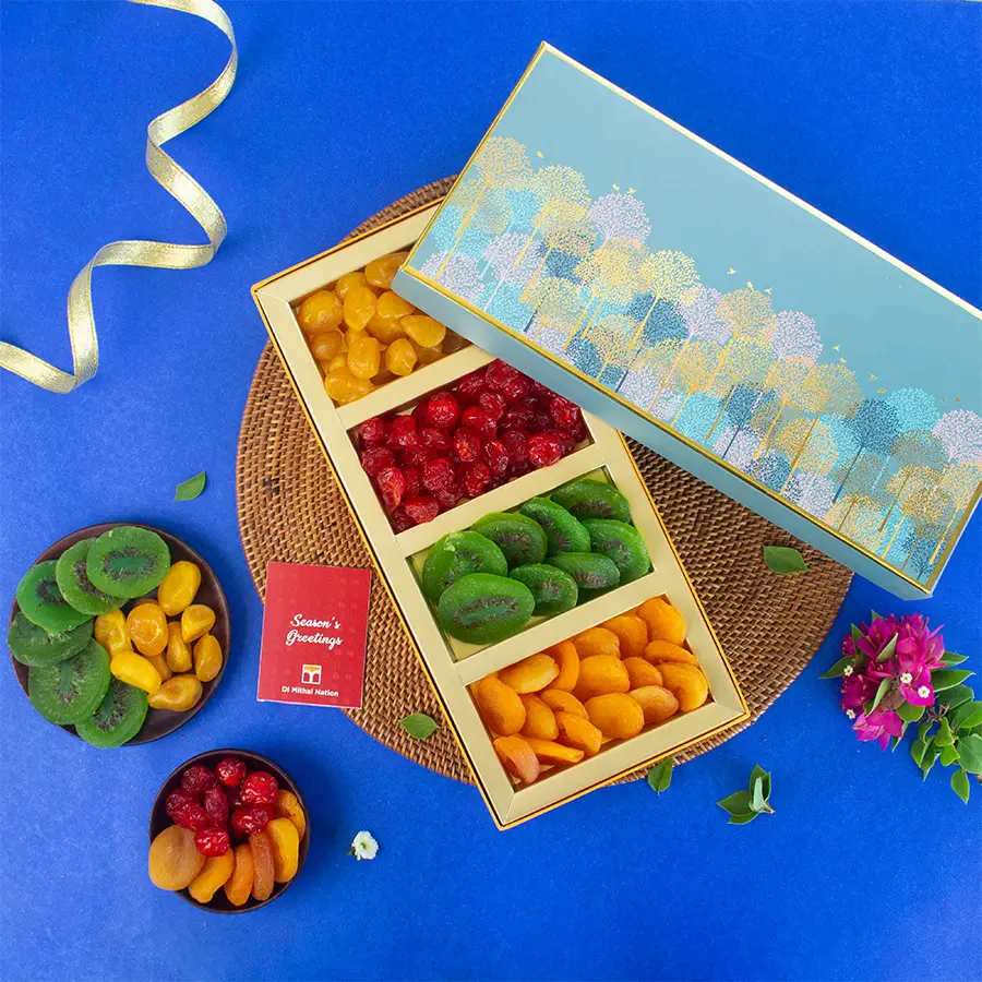 Dried Fruity Delight Box featuring sun-dried kiwi, baby lemon, cherry, and apricots with a classic blue tree design and a festive greeting card.