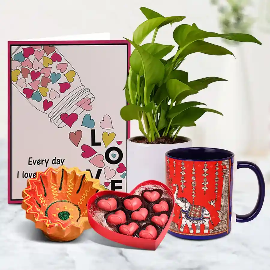 Joyful Diwali Gift Assortment featuring a Diya, heart-shaped chocolates, a printed coffee mug, a money plant in a pot, and a message card