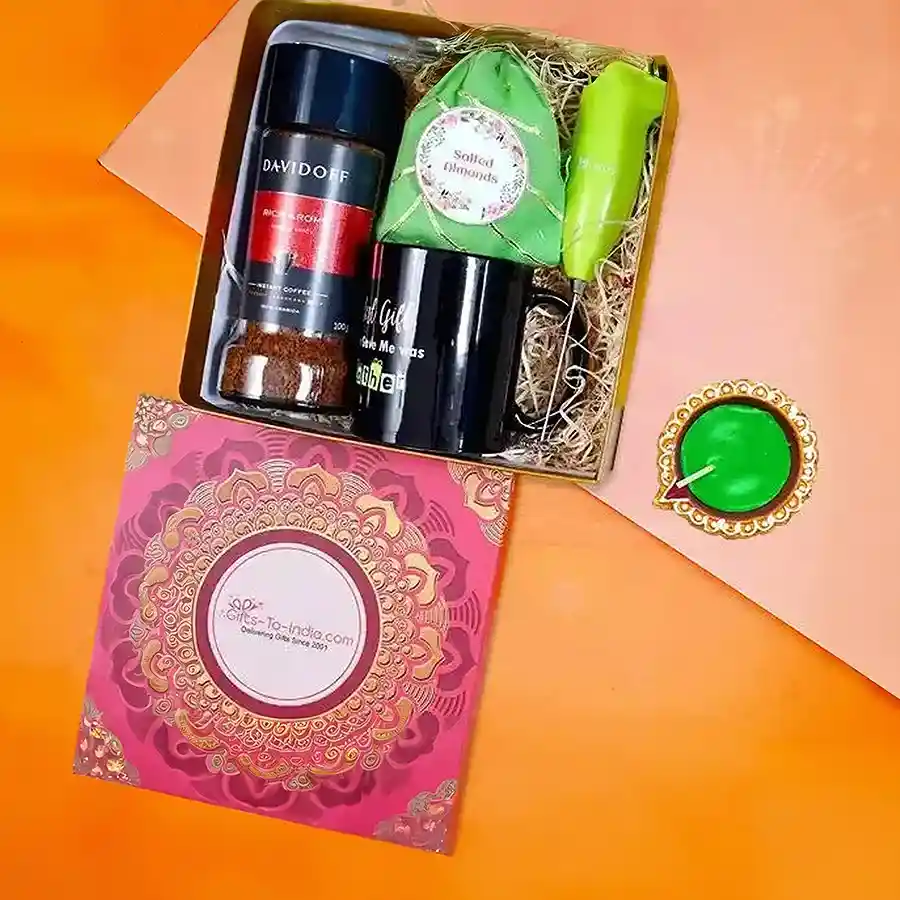 Almonds and coffee essentials hamper featuring a traditional Diya, a quote-filled mug, an electric hand coffee blender, and premium roasted almonds, set against a festive backdrop.
