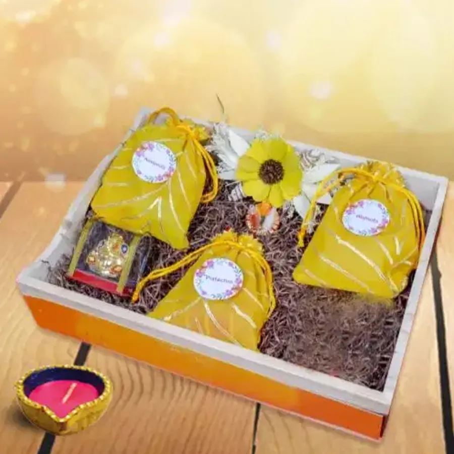 Diwali Nuts and Luminous Diya Hamper featuring a glowing diya and bowls of roasted pistachios, almonds, and walnuts.