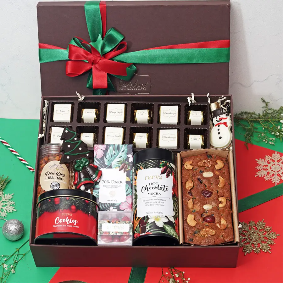 Box of Dazzling Dozen Assorted Chocolates with various delights including chocolates, trail mix, lollipops, dark Belgian chocolate, cranberry dragees, strawberry log, chocolate snowman, hot mocha tin, fruit and nut tea cake, and cookies in a tin.